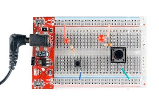 Un circuito simple, que implica un botón, un LED, y una resistencia, construido de dos maneras diferentes.